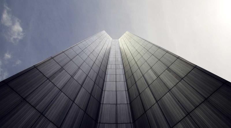 A glass office tower seen from below